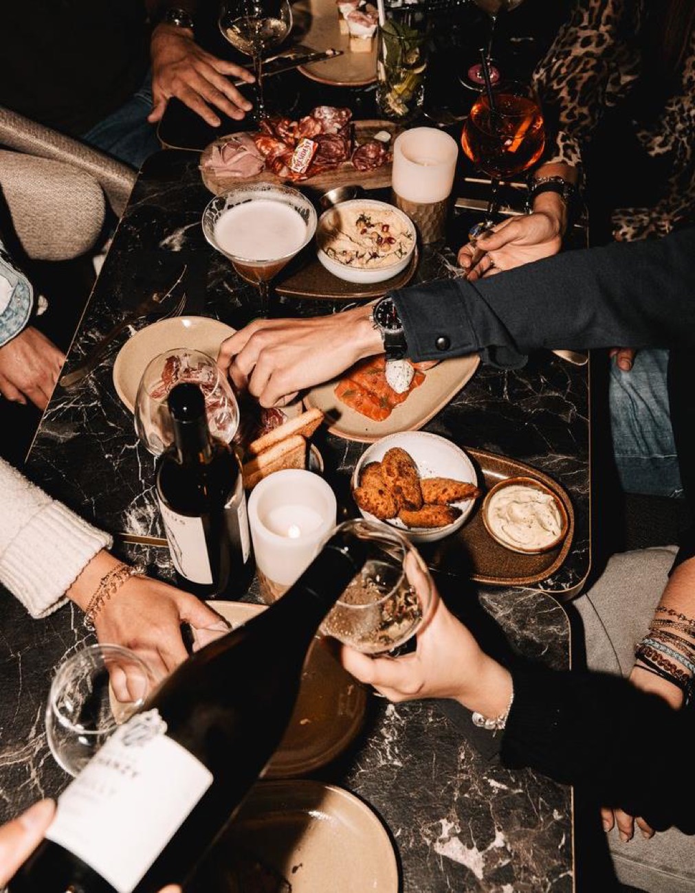 Glasses meeting over a full table