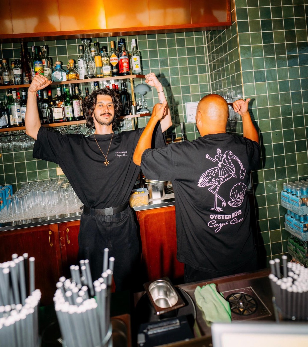 Two bartenders against green tiles