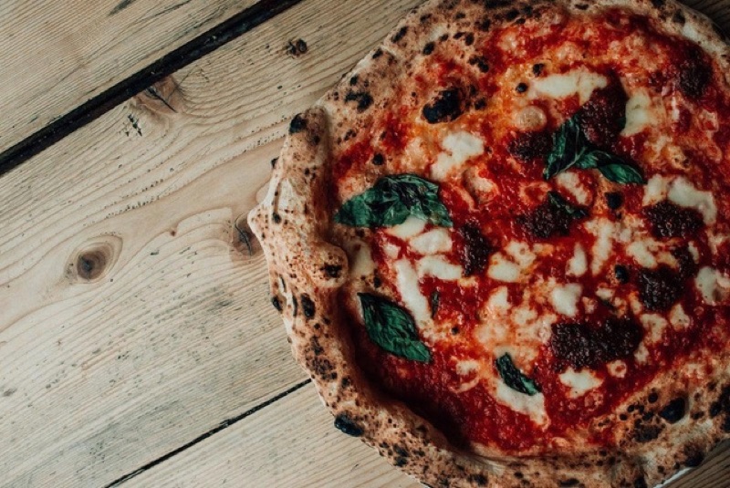 A wood-fired pizza on a board