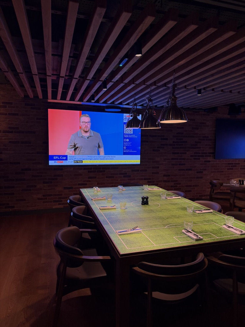 A private dining table printed as a football pitch