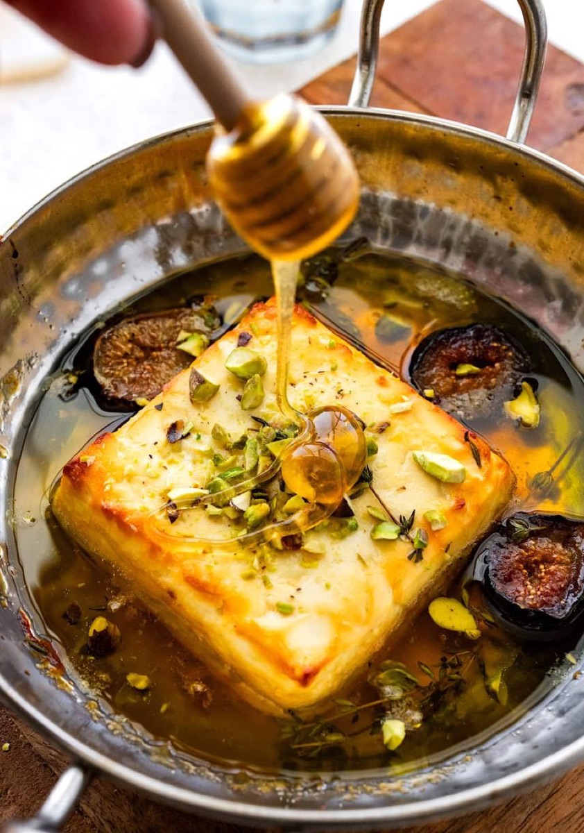 Baked cheese with honey, figs and pistachio in a copper pan